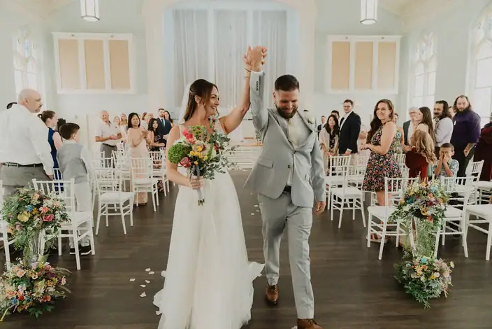 Newlyweds celebrating at the end of their ceremony in the Blackburn Ballroom