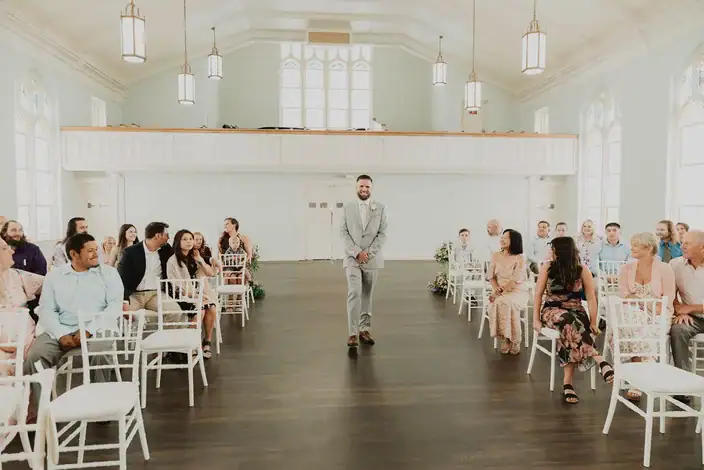 Groom walking down the aisle in the Blackburn Ballroom
