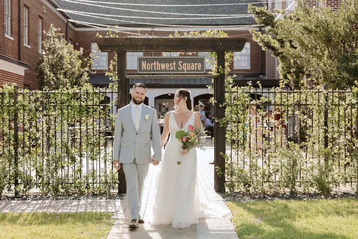 Bride and groom walking through the Northwest Square courtyard gate