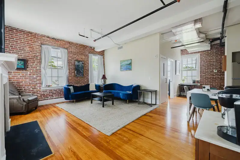 Apt 201 living room with exposed brick walls and hardwood floors