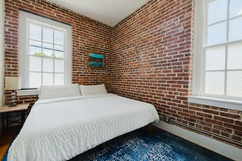 Apt 201 bedroom with brick walls and original windows