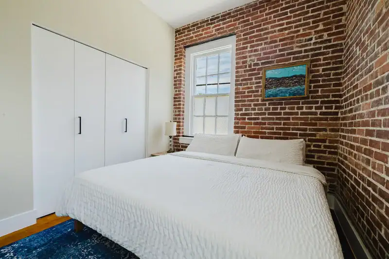 Apt 201 bedroom with built-in closet and brick wall