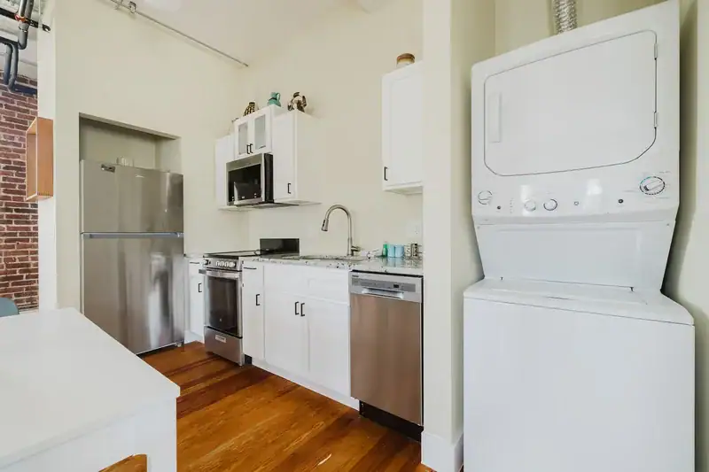 Apt 201 kitchen with stainless refrigerator and stacked laundry