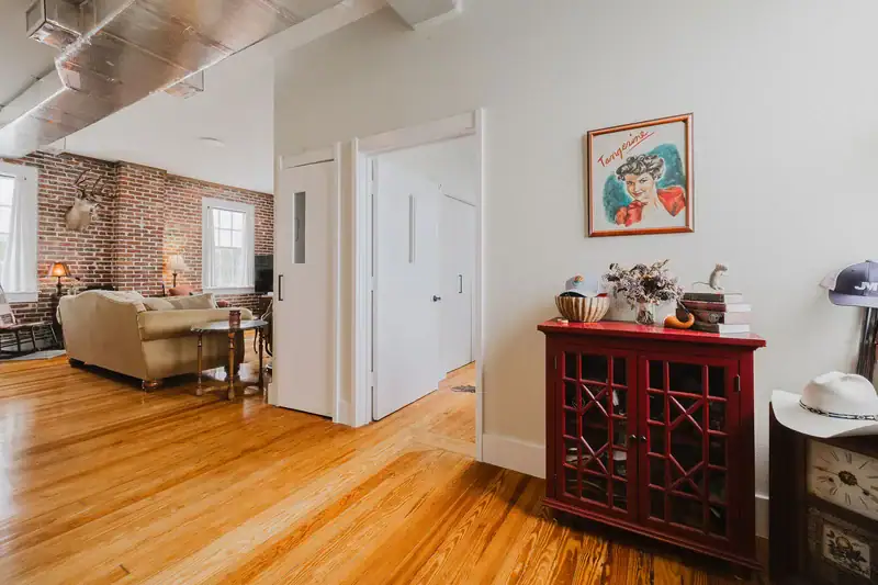 Hallway in Apartment 301 with hardwood floors and a view into the living room