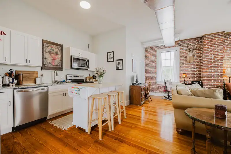 Kitchen in Apartment 301 looking across the breakfast bar into the brick-walled living area
