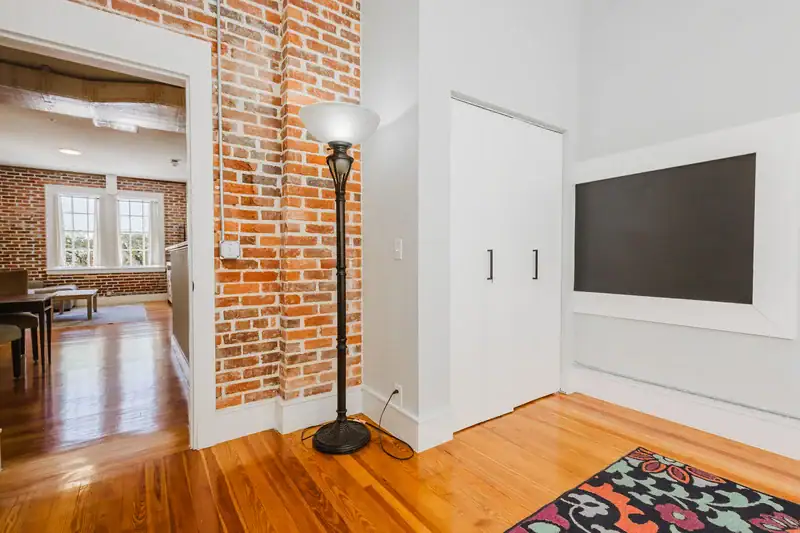 Apartment 303 bedroom with closet, floor lamp and exposed brick