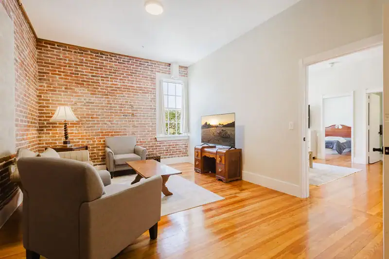 Apartment 303 sitting area with television and doorway to the bedroom