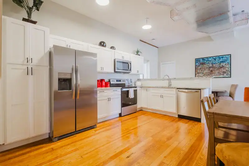 Apartment 303 kitchen with white cabinets, stainless steel appliances and hardwood floors