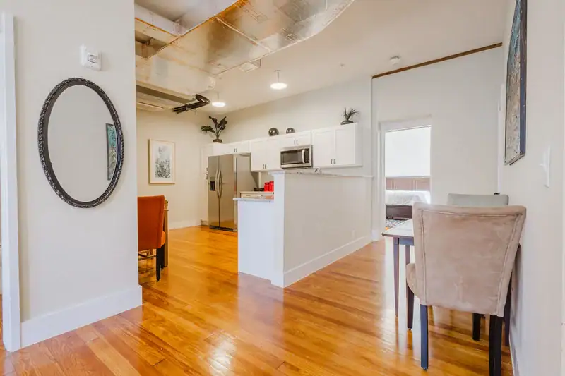 Apartment 303 hallway with oval mirror looking toward the kitchen